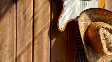 Tahtada klasik elektro gitar ve kovboy şapkası..