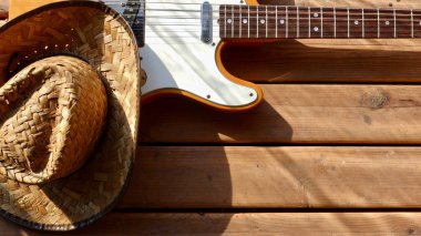 Tahtada klasik elektro gitar ve kovboy şapkası..