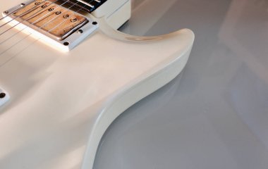 Beyaz elektro gitar yakın plan. Kopyalama alanı olan beyaz arkaplan 