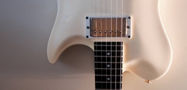 Beyaz elektro gitar yakın plan. Kopyalama alanı olan beyaz arkaplan 