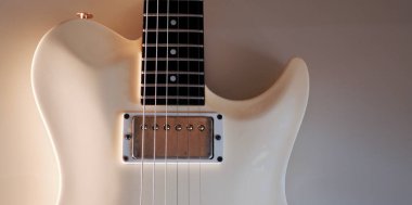 Beyaz elektro gitar yakın plan. Kopyalama alanı olan beyaz arkaplan 