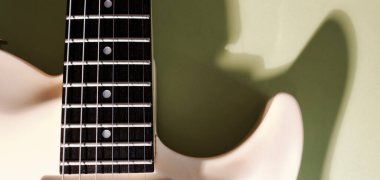 Beyaz gitar yakın plan. kopyalama alanı olan renk arkaplanı