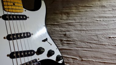 Elektro gitar kapanışı. Beyaz duvar yakın plan 