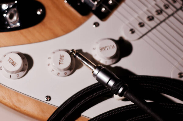 Vintage electric guitar with instrumental cable closeup