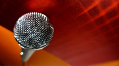 Gümüş renkli stüdyo mikrofonu. Kopyalama alanı olan kırmızı arkaplan