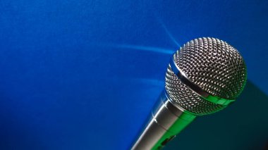 Gümüş renkli stüdyo mikrofonu. Kopyalama alanı olan mavi arkaplan