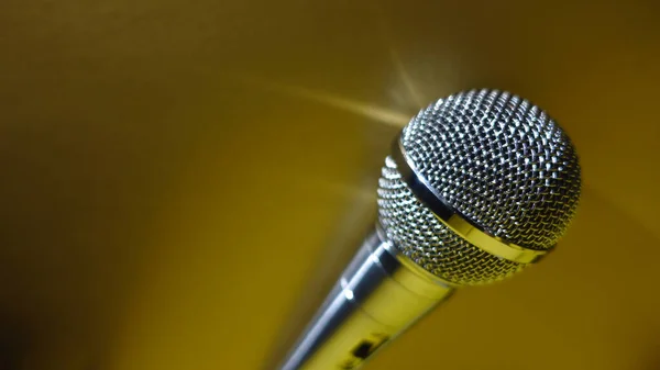 Silver studio microphone . Gold background with copy space