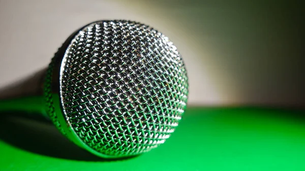 Gümüş renkli stüdyo mikrofonu. Kopyalama alanı olan yeşil arkaplan