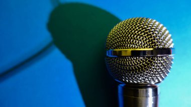 Gümüş renkli stüdyo mikrofonu. Kopyalama alanı olan mavi arkaplan