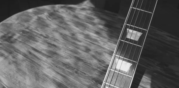 Electric guitar on the wooden boards . Black and white