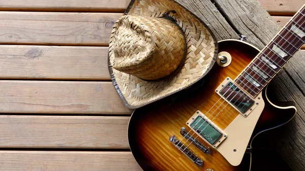 Tahtada elektro gitar ve kovboy şapkası.