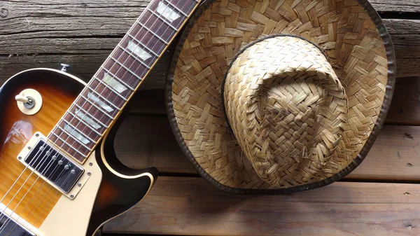 木制木板上的老式电吉他和牛仔帽 复制空间 — 图库照片