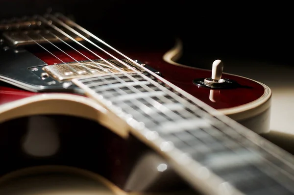 Red wine electric guitar closeup . dark background