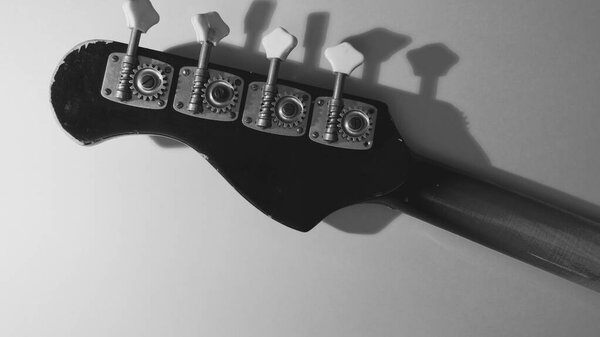 Old bass guitar headstock closeup . black and white