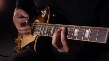 Gitarist elektro gitar çalar. Yavaş çekim 100p