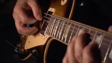 Gitarist elektro gitar çalar. Yavaş çekim 100p