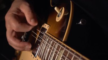 Gitarist elektro gitar çalar. Yavaş çekim 100p