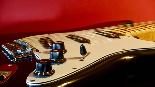 Electric guitar closeup . Red background
