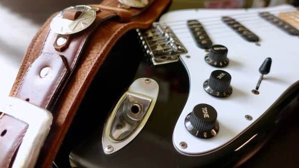 Electric guitar closeup and guitar strap .