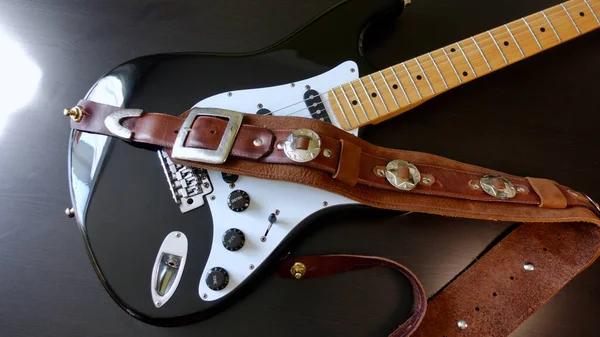 Electric guitar closeup and guitar strap .