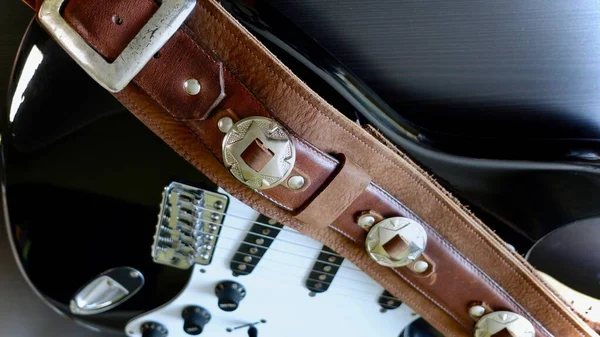 Electric guitar closeup and guitar strap .