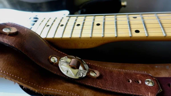 Electric guitar closeup and guitar strap .