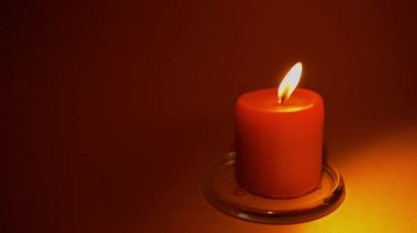 Yanan kırmızı mum. Kırmızı arka plan. Yavaş çekim 50p