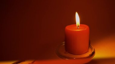 Yanan kırmızı mum. Kırmızı arka plan. Yavaş çekim 50p