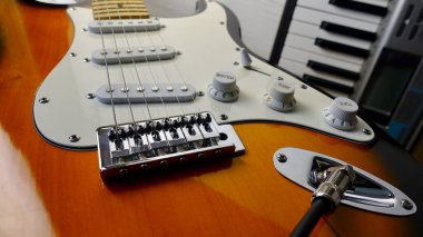 Elektro gitar ve piyano klavyeleri yakın plan. Kopyalama alanı olan beyaz arkaplan