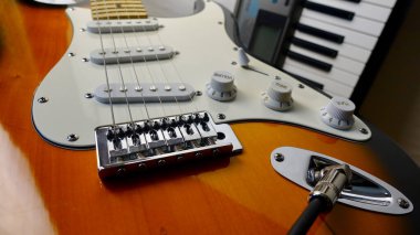 Elektro gitar ve piyano klavyeleri yakın plan. Kopyalama alanı olan beyaz arkaplan