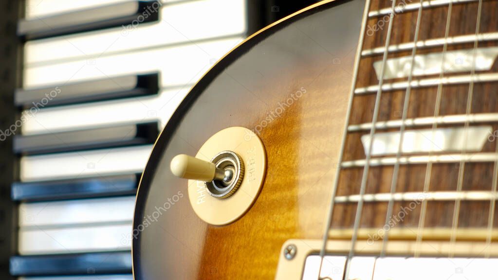 Electric guitar and piano keyboards closeup . dark background