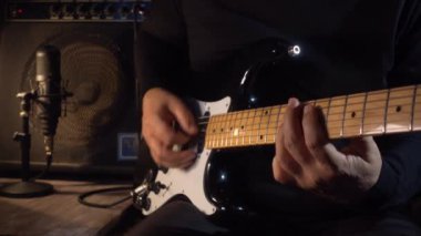 Gitarist stüdyoda elektro gitar çalıyor. Yavaş çekim 100p