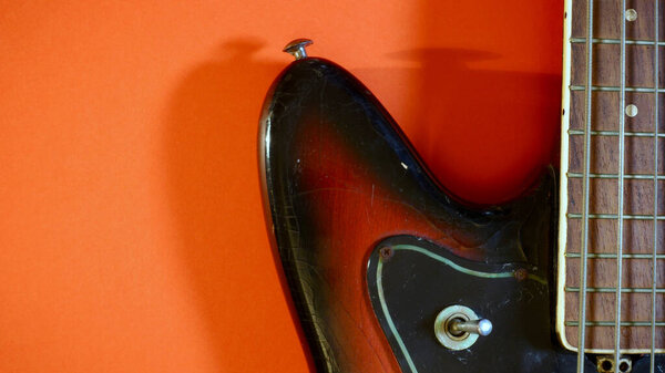 Old bass guitar closeup . Color background with copy space
