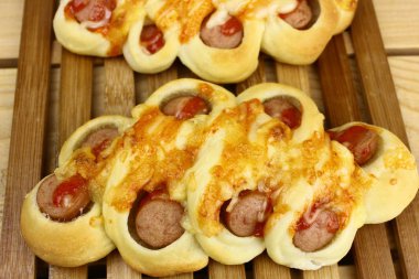 Ahşap masada nefis bir fırın, sosisli ekmek.