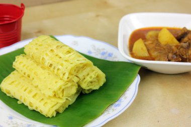 Ahşap masa arkasında nefis pişmiş yemekler.