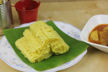 Ahşap masa arkasında nefis pişmiş yemekler.