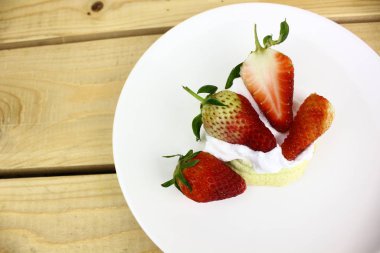 ahşap masanın üzerinde çilek kremalı kopyasal alan 