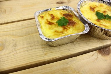 Ahşap arka planda folyo kalıplı lezzetli kır evi turtaları.