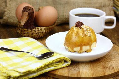 Ahşap zemin üzerinde kahve fincanı olan lezzetli hamur işi.