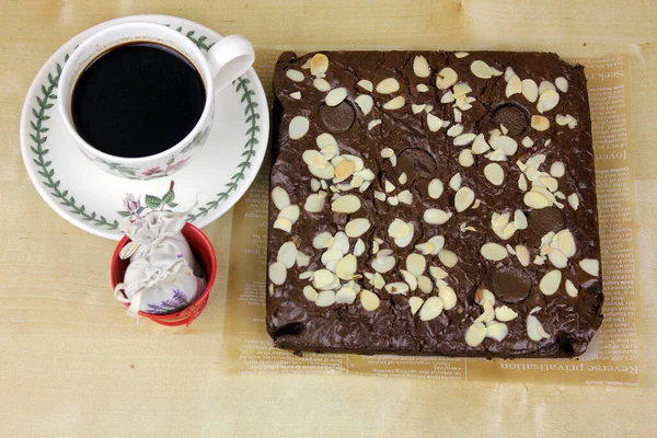 tasty chocolate cake with nut pieces and cup of coffee