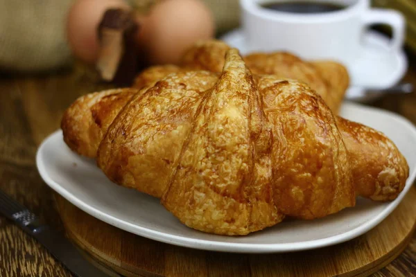 Los Croissants Plato Blanco Taza Del Café Sobre Superficie Madera — Foto de Stock