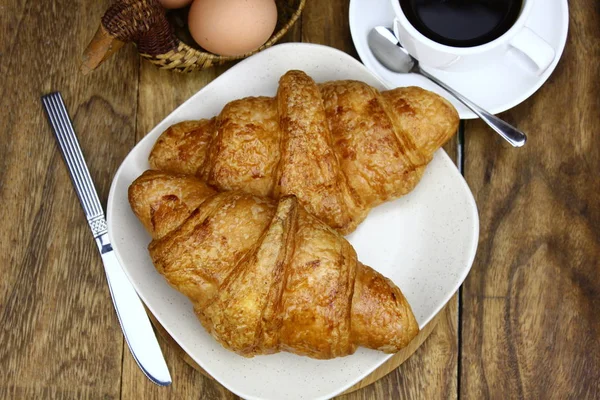 Croissants Weißem Teller Und Tasse Kaffee Auf Einer Holzoberfläche Das — Stockfoto