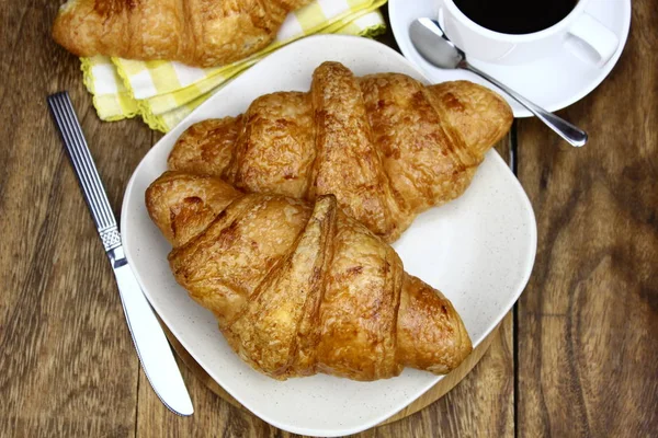Croissants Placa Branca Xícara Café Uma Superfície Madeira Conceito Alimento — Fotografia de Stock