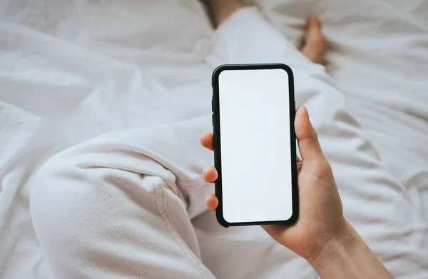 Woman holding a smartphone with a white screen. Mock up — Stock Photo, Image