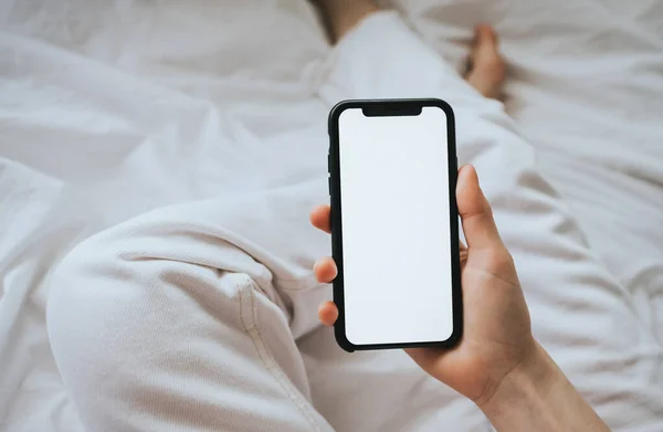 Woman holding a smartphone with a white screen. Mock up — Stock Photo, Image