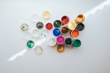 Gouache beyaz arka planda plastik kavanozlara resim yapıyor..