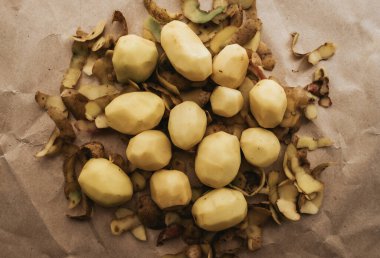 Kabuğu soyulmuş beyaz patates ve el işi kağıt..