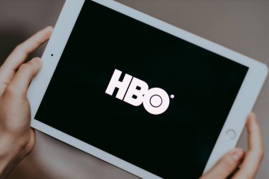 Eller HBO logo ekranlı iPad 'i tutuyor.