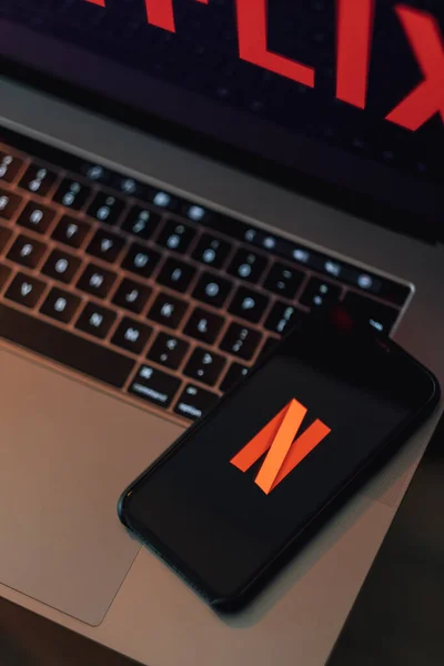 Smartphone y portátil con pantalla del logotipo de Netflix . — Foto de Stock