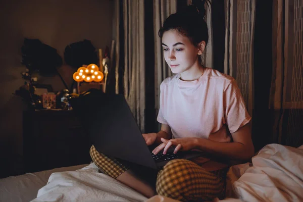 Fiatal nő használja laptop otthon este — Stock Fotó